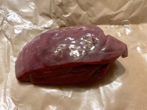 A glistening purple-red piece of liver that resembles a piece of sashimi